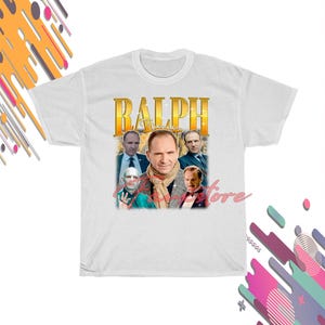 May include: A white ceramic mug with a black handle and the text "But First, Coffee" in a bold, black font. The mug is set against a blurred background, suggesting a cosy setting.