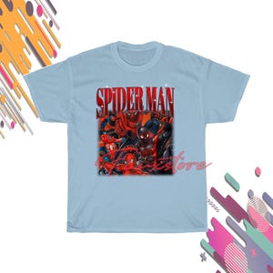 Puede incluir: Camiseta azul claro con un gr&aacute;fico de personajes de Spider-Man y el texto "SPIDER MAN" en rojo. El dise&ntilde;o presenta varios trajes y poses de Spider-Man, creando una composici&oacute;n din&aacute;mica y colorida.