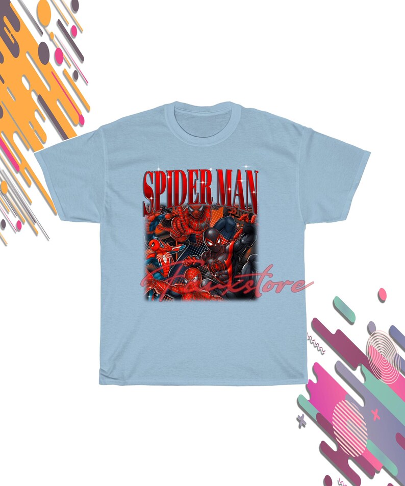 Puede incluir: Camiseta azul claro con un gr&aacute;fico de personajes de Spider-Man y el texto "SPIDER MAN" en rojo. El dise&ntilde;o presenta varios trajes y poses de Spider-Man, creando una composici&oacute;n din&aacute;mica y colorida.