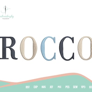 May include: The name "ROCCO" is displayed in a stylized font, with each letter in a different color: navy blue, beige, light blue, navy blue, and beige. The image includes the text "Embroideryby TOUSEEF" and embroidery file format abbreviations.