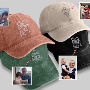 Op de afbeelding: Baseballpetten in roest, groen, beige en zwart. Elke pet heeft een witte lijntekening van een persoon die kinderen vasthoudt. Er zijn ook kleine foto's van mensen met kinderen inbegrepen.