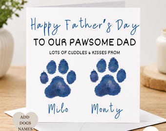 May include: A square white greeting card featuring the blue and black text Happy Father's Day TO OUR PAWSOME DAD LOTS OF CUDDLES & KISSES FROM. Below the text are two blue watercolor paw prints with the names Milo and Monty printed in blue.