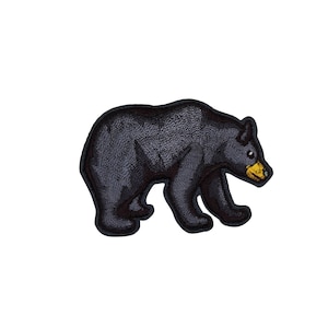 May include: Embroidered black bear patch with a yellow snout and small black eyes. The bear is depicted in a walking pose, with detailed stitching creating a textured appearance. This patch is suitable for jackets, bags, or other fabric items.