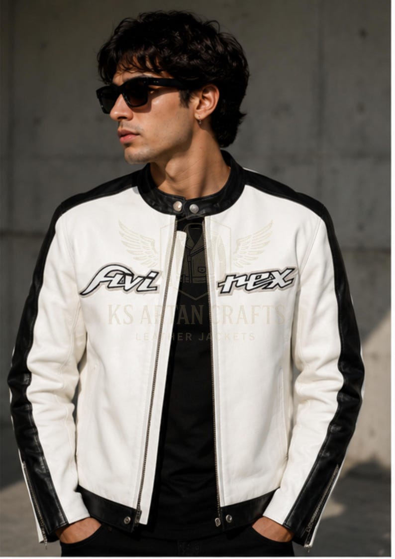 May include: White leather jacket with black accents on the shoulders and sleeves. The jacket features the text "Avi Rex" on the chest and "KS AAN CRAFT LEATHER JACKETS" below. The jacket has a zipper closure and a round collar.