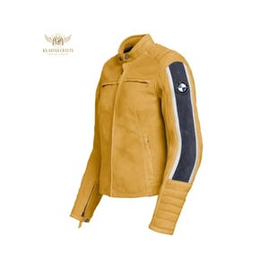 Puede incluir: Chaqueta de cuero amarillo mostaza con una franja negra y blanca en la manga. La chaqueta tiene un dise&ntilde;o acolchado en los hombros y la parte inferior de las mangas, cierre de cremallera y un parche con el logo de BMW.