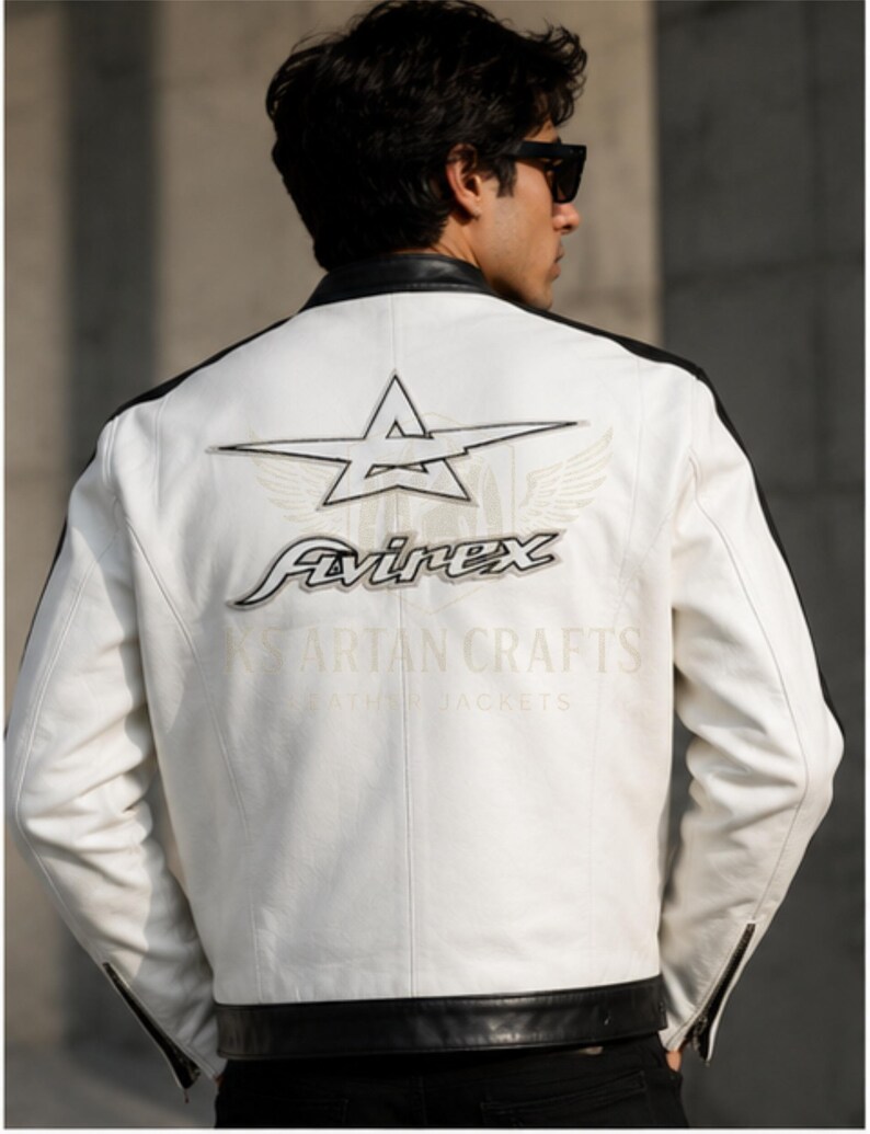 May include: White leather jacket with black accents and a star logo on the back. The jacket features the "Avirex" logo and the text "Spartan Crafts Leather Jackets". The jacket has a zipper on the sleeves.