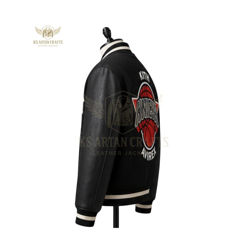 May include: Black leather jacket with white and black striped collar and cuffs. Features a red and white basketball graphic with the word "Knights" and the brand name "Kith". The jacket is displayed on a mannequin.