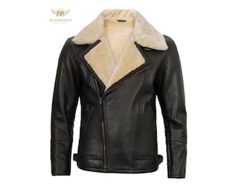May include: A dark brown leather jacket with a cream-colored shearling lining and collar. The jacket features a diagonal zipper closure, a wide lapel, and a classic aviator style. The jacket has a logo on the upper left side.