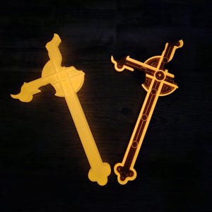 May include: Two wooden crosses with intricate designs. One is a simple cross shape, while the other has a more ornate, detailed design. Both crosses have a warm, glowing effect against a dark background.