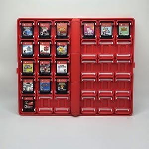 May include: Red Nintendo Switch game case with 18 game cartridges inserted. The cartridges include games like Pokemon, Mario Kart, and Super Smash Bros.