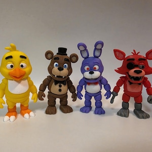 May include: Four colorful action figures of characters from a popular video game franchise. The figures include a yellow chick, a brown bear with a black hat, a purple rabbit, and a red fox. Each figure has a unique design.