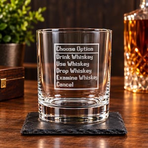 May include: A clear glass tumbler featuring an etched white rectangular menu box with the text: Choose Option, Drink Whiskey, Use Whiskey, Drop Whiskey, Examine Whiskey, Cancel. The glass has a thick base and smooth, transparent walls.
