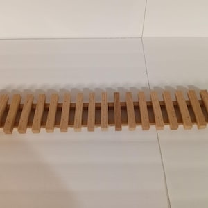 May include: A wooden slatted rack with 20 evenly spaced slats. The rack is made of natural wood and is approximately 20 inches long.