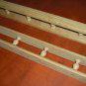 May include: Two wooden coat racks with a rustic finish. Each rack has five hooks, with the top rack having simple hooks and the bottom rack having hooks shaped like bowling pins.