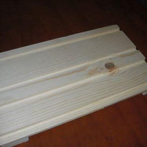 May include: A plain wooden board with a knot in the wood. The board has a smooth surface and is made of light-colored wood.