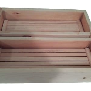 May include: A wooden box with two removable trays. The box is made of light wood and has a natural finish. The trays are also made of wood and have a smooth surface.