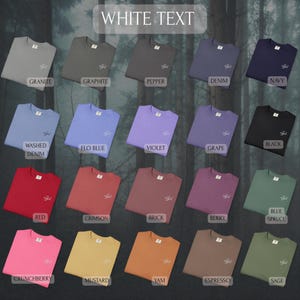 May include: A collection of twenty crewneck t-shirts displayed in a grid, each featuring a small embroidered design on the left chest. The shirts are available in various colors including granite, graphite, pepper, denim, navy, washed denim, flo blue, violet, grape, black, red, crimson, brick, berry, blue spruce, crunchberry, mustard, yam, espresso, and sage.