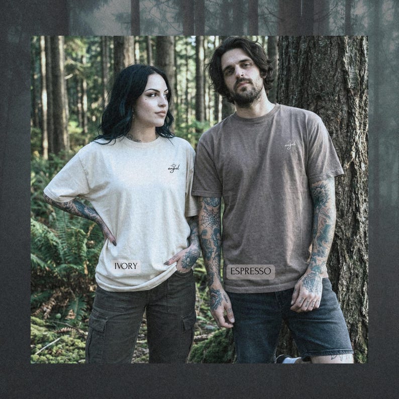 May include: Two short-sleeved crew neck t-shirts. The left shirt is ivory with the word angel printed in black on the chest and the word IVORY below. The right shirt is espresso brown with the word angel printed in white and ESPRESSO below.