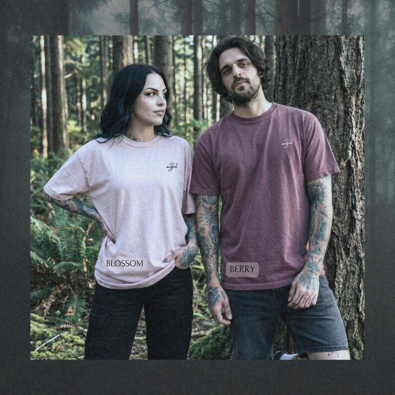 May include: Two short-sleeved crew neck t-shirts. One is a light pink shirt labeled Blossom with the word angel printed on the chest. The other is a dark berry red shirt labeled Berry with the word angel printed on the chest. Both shirts are plain.