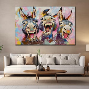 May include: A large canvas print depicting three donkeys mid-laugh, with open mouths and expressive faces. The artwork uses thick brushstrokes and a bright colour palette of blues, pinks, and yellows, creating a cheerful and playful image.