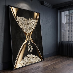 May include: A framed wall art print featuring a gold hourglass with a black background. The top and bottom chambers of the hourglass are filled with a large quantity of US dollar bills, with several individual bills falling through the centre.