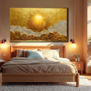 Könnte beinhalten: Ein großes, strukturiertes, gold-weißes abstraktes Gemälde einer Sonne und Wolken hängt über einem hölzernen Bettrahmen. Das Schlafzimmer hat eine neutrale Farbpalette mit einer Pflanze in einem geflochtenen Korb und zwei Pendelleuchten.