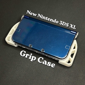 May include: A blue New Nintendo 3DS XL handheld game console with a white grip case. The text "New Nintendo 3DS XL" and "Grip Case" are displayed in white. The console is on a dark gray surface.