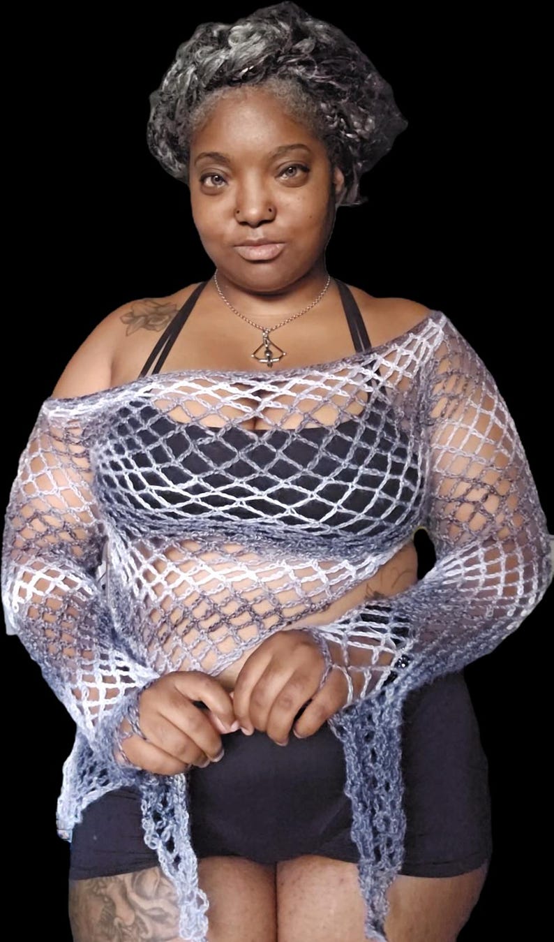 May include: A long-sleeved, off-the-shoulder crochet top featuring an open, diamond-shaped net pattern. The garment is crafted from a variegated yarn that transitions between shades of dark charcoal gray, light gray, and white in a gradient effect.
