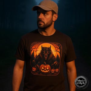Könnte beinhalten: Dunkelbraunes T-Shirt mit einem Halloween-Motiv. Das Design zeigt einen Werwolf, Kürbisse und einen Vollmond. Das T-Shirt hat einen Rundhalsausschnitt und kurze Ärmel. Der Text "Monster & Myth" befindet sich unten rechts.