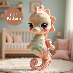 Puede incluir: Un muñeco de caballito de mar tejido a ganchillo en suaves colores pastel. El caballito de mar tiene ojos grandes y expresivos, mejillas rosadas y una cola enroscada. El texto "PDF Pattern" está en un círculo en la esquina superior izquierda. Es un artículo hecho a mano.