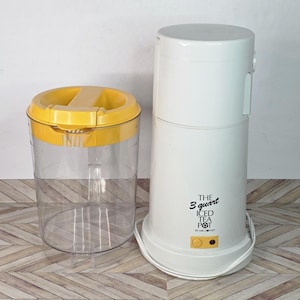 以下が含まれることがあります： 黄色い蓋の透明なプラスチック容器と、白い3クォート（約2.84リットル）のアイスティーポット。 ティーポットは白いボディで、「THE 3 quart ICED TEA POT」の文字と黄色のボタンが付いています。