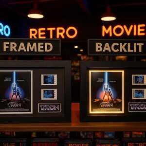 two framed movie posters for the film "Tron" displayed in a store, with neon signs indicating the categories of the store.