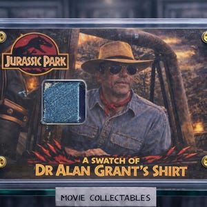 May include: Framed movie memorabilia with a fabric swatch from Dr. Alan Grant's shirt in Jurassic Park. The display includes the film's logo, a portrait of the character, and the text "A Swatch of Dr. Alan Grant's Shirt."