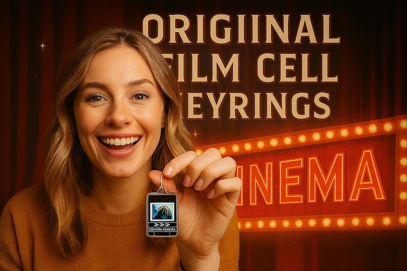 A smiling woman holding a small keychain with a picture on it, standing in front of a sign that says "ORIGINAL FILM CELL EYBRINGS" and a neon sign that says "INEMIA".