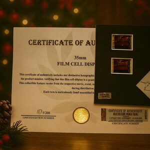The image is a limited edition certificate of authenticity for a 35mm film cell disp, featuring a film cell disp and two film cell disp stamps.