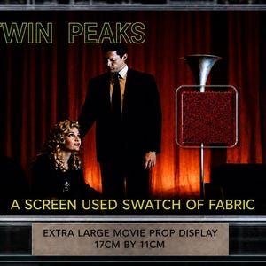 Könnte beinhalten: Ein gerahmtes Filmrequisiten-Display mit dem Text "TWIN PEAKS" und "EIN GEBRAUCHTES STOFFMUSTER". Das Display zeigt eine Szene mit zwei Personen und einem roten Vorhanghintergrund. Das Display misst 17 cm x 11 cm.
