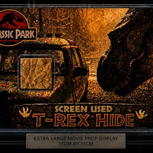 Pode incluir: Uma exibição emoldurada de adereços do filme Jurassic Park. A exibição apresenta o logotipo do Jurassic Park, uma cabeça de T-Rex e um pedaço de pele de T-Rex usado na tela. A exibição mede 17 cm por 11 cm.