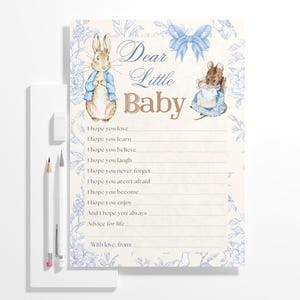 Może przedstawiać: Kartka z radami na baby shower z niebieskim i białym wzorem kwiatowym. Na kartce znajdują się ilustracje Królika Piotrusia i myszy. Tekst na kartce brzmi "Drogi mały maluszku" i zawiera listę rad dla dziecka.