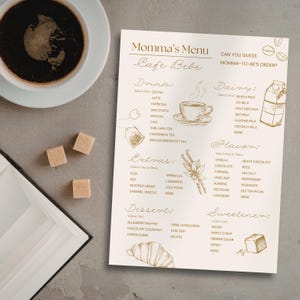 May include: A coffee cup, sugar cubes, and a menu titled "Momma's Menu Cafe Bebe" are displayed. The menu lists drink, dairy, flavor, extra, dessert, and sweetener options, with illustrations of coffee, a milk carton, and a croissant.