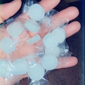以下が含まれることがあります： 個別に包装された、水色の丸いキャンディーの束。キャンディーは透明でしわのあるプラスチック包装に入っています。画像はわずかに上から撮影されており、キャンディーがフレームを埋めています。