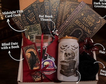 May include: A gift box containing a set of five dark academia greeting cards, a Midnight TBR card deck, a bat book thumb, a blind date with a book, a dark red hair claw, black fuzzy socks, and a frosted glass tumbler with a skull and book print.
