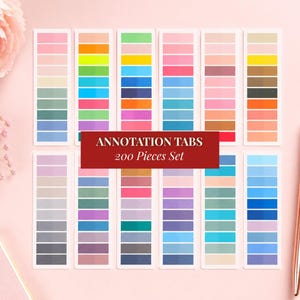 May include: A set of 200 adhesive annotation tabs arranged in twelve vertical strips, featuring a wide variety of solid colours including pastels, brights, and neutrals. A dark red rectangular label in the centre reads ANNOTATION TABS 200 Pieces Set.