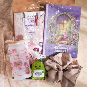 May include: A gift box containing a purple reading journal, a glass water bottle with floral designs and the text "Just one more chapter", a green crocheted cactus, and a beige scrunchie. The journal has a floral illustration.