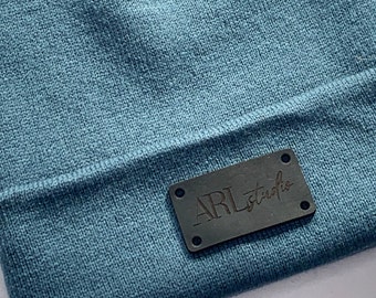 Laser engraved logo leather tag for Beanie hat. Personalised hat label for businesses. Corporate gifting.