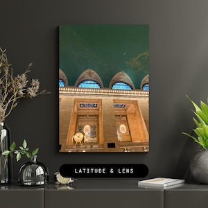 May include: A photograph of the interior of a grand building with a green ceiling and ornate arches. The ceiling is decorated with a pattern of stars. There are large windows and chandeliers hanging from the ceiling.