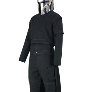 May include: A black costume with a silver helmet. The outfit includes a long-sleeved top, trousers with knee padding, and a long, flowing piece of fabric attached to the trousers. The helmet is shiny and reflective.