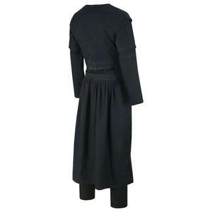May include: A black outfit comprising a long-sleeved top with a waist detail, a long skirt, and fitted trousers. The top has a V-neck and the skirt is pleated. The outfit appears to be made of a dark fabric.