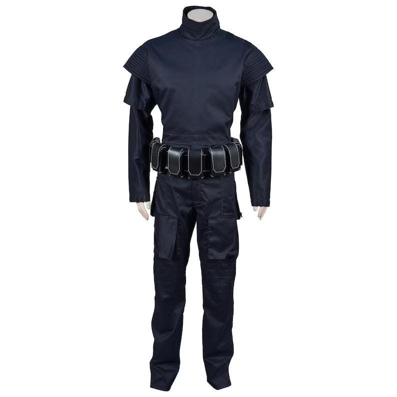 May include: A dark navy blue costume with a high collar, shoulder pads, and a utility belt. The long-sleeved top and pants are a matching color. The costume has a futuristic or military-inspired design.