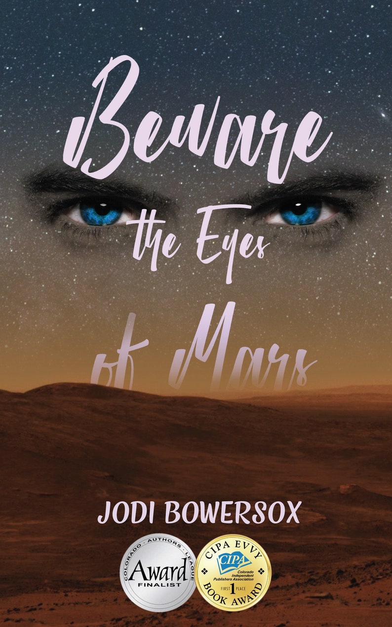 May include: Book cover with a red, rocky landscape and a pair of blue eyes looking out from the sky. The title is "Beware the Eyes of Mars" and the author is Jodi Bowersox. The book has won a Colorado Independent Publishers Association (CIPA) Evvy Award for First Place Book Award and was a finalist for the Colorado Authors League Award.