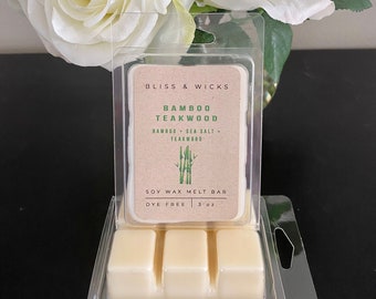 May include: A clear plastic package containing a soy wax melt bar. The bar is labeled "Bliss & Wicks Bamboo Teakwood" and is dye-free. The scent is described as "Bamboo + Sea Salt + Teakwood". The bar is 3 oz.